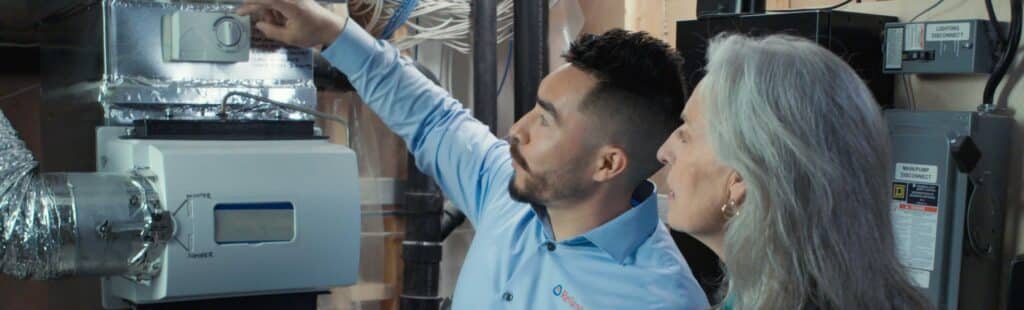 Home advisor and a female customer looking at a furnace